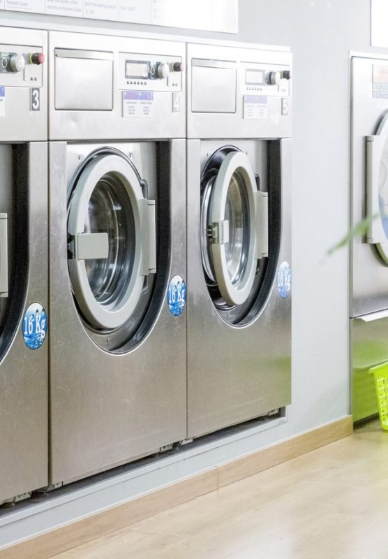 Public laundry with modern, silver washing machines in a row
